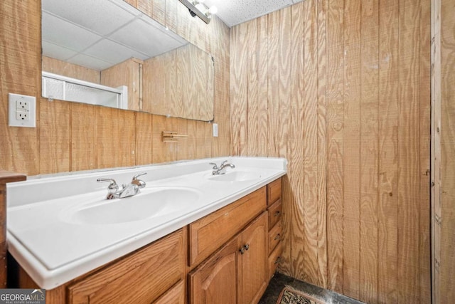 bathroom with double vanity, a sink, and a paneled ceiling