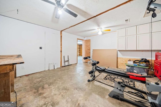 workout area with a textured ceiling and a ceiling fan