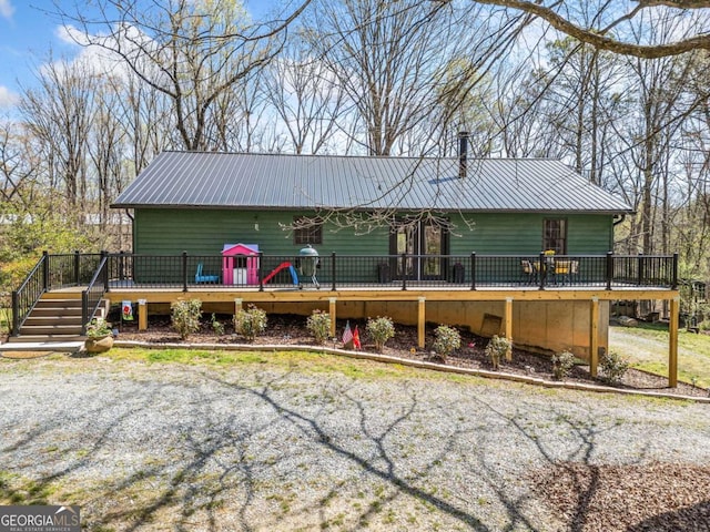 view of front facade with metal roof and a wooden deck