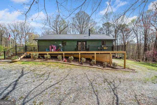 view of front of home with metal roof, a chimney, and a wooden deck