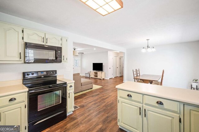kitchen with light countertops, a notable chandelier, dark wood-style floors, and black appliances