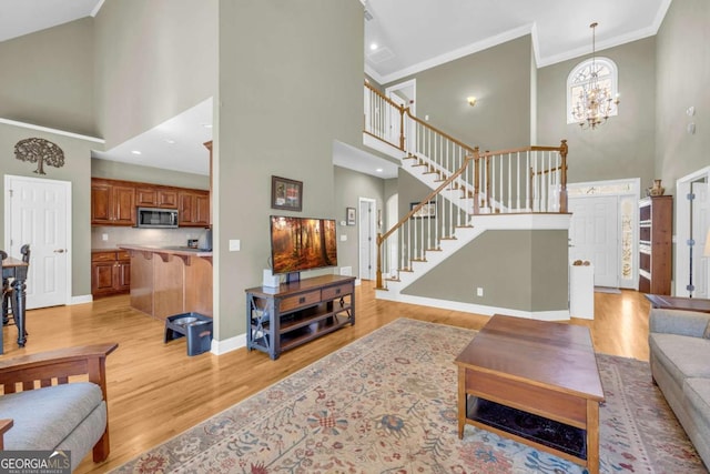 4463 N Gate Dr, Gainesville, GA 30506 - living area with stairs, a high ceiling, baseboards, light wood-style floors, and ornamental molding