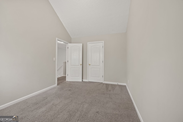 60 Charlotte Blvd, Stockbridge, GA 30281 - spare room featuring a textured ceiling, lofted ceiling, carpet floors, and baseboards