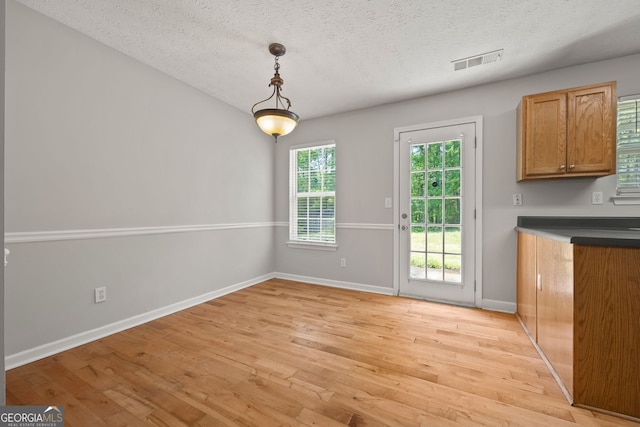 60 Charlotte Blvd, Stockbridge, GA 30281 - unfurnished dining area featuring light wood finished floors, baseboards, visible vents, and a textured ceiling