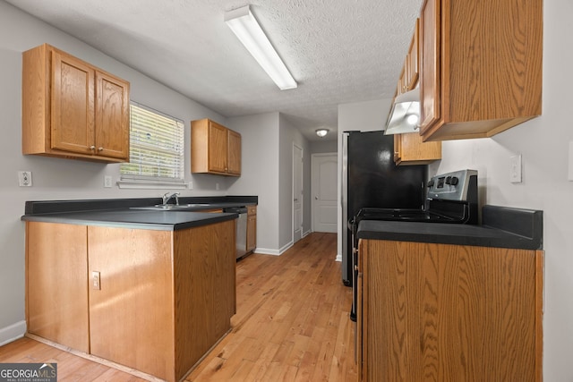 60 Charlotte Blvd, Stockbridge, GA 30281 - kitchen with a peninsula, dark countertops, a textured ceiling, and light wood finished floors