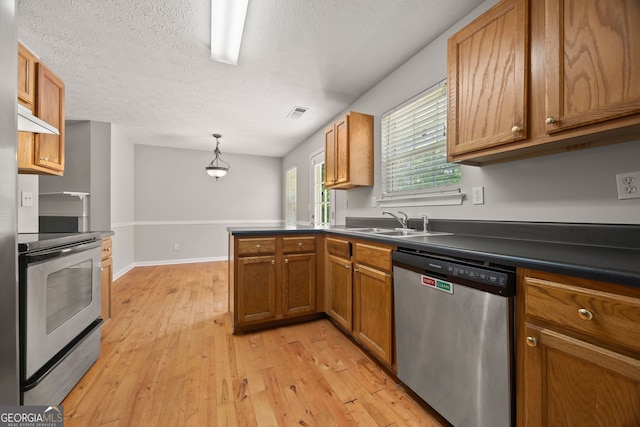 60 Charlotte Blvd, Stockbridge, GA 30281 - kitchen with dark countertops, a sink, brown cabinets, stainless steel appliances, and light wood finished floors