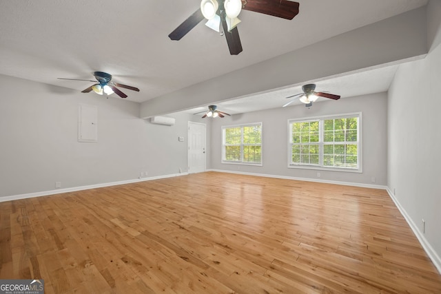 60 Charlotte Blvd, Stockbridge, GA 30281 - unfurnished living room with ceiling fan, baseboards, light wood finished floors, and a wall unit AC