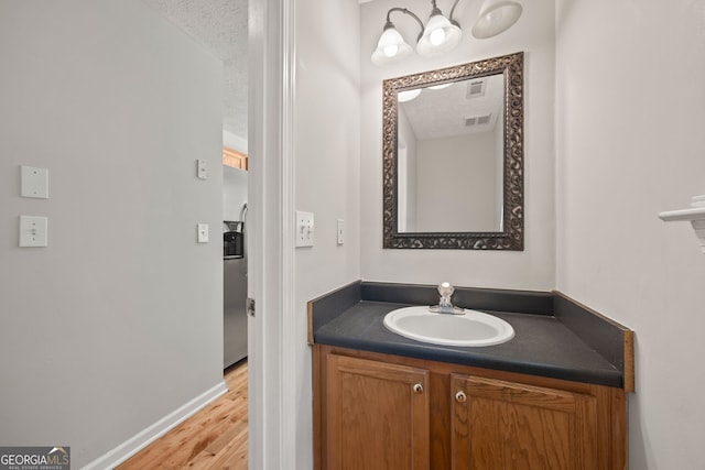 60 Charlotte Blvd, Stockbridge, GA 30281 - bathroom featuring baseboards, wood finished floors, visible vents, and vanity