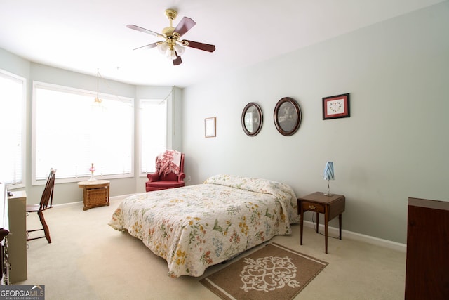 bedroom featuring light colored carpet, ceiling fan, and baseboards