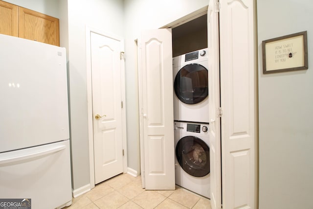 washroom with stacked washer / drying machine, laundry area, and light tile patterned floors