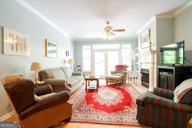 living room with a fireplace with flush hearth, ceiling fan, wood finished floors, and ornamental molding