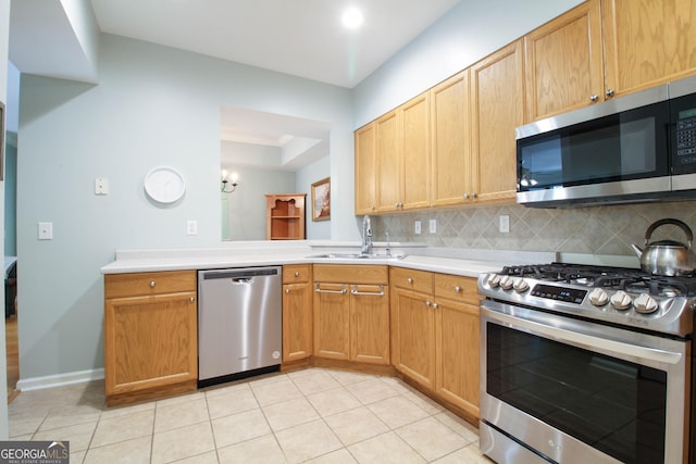 kitchen with light countertops, light tile patterned floors, stainless steel appliances, backsplash, and a sink