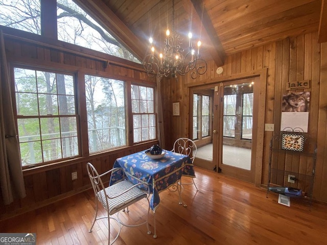 364 Cardinal Ln, Toccoa, GA 30577 - dining area with lofted ceiling, wooden walls, healthy amount of natural light, a chandelier, and wood-type flooring