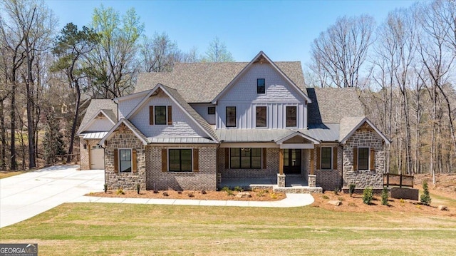 100 Forest Pl, Forsyth, GA 31029 - view of front of home featuring covered porch, concrete driveway, stone siding, a standing seam roof, and a front lawn