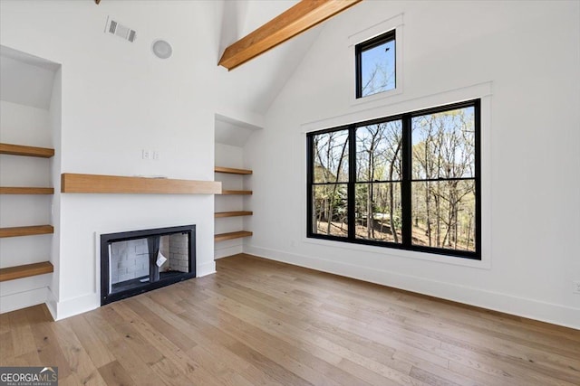 100 Forest Pl, Forsyth, GA 31029 - unfurnished living room with high vaulted ceiling, a fireplace, hardwood / wood-style floors, beam ceiling, and baseboards