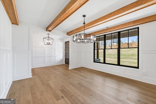 100 Forest Pl, Forsyth, GA 31029 - unfurnished dining area featuring a decorative wall, a chandelier, beam ceiling, light wood-style floors, and wainscoting