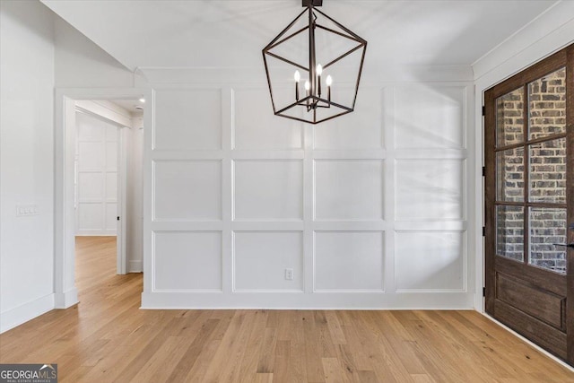 100 Forest Pl, Forsyth, GA 31029 - unfurnished dining area featuring a decorative wall, a chandelier, and light wood finished floors