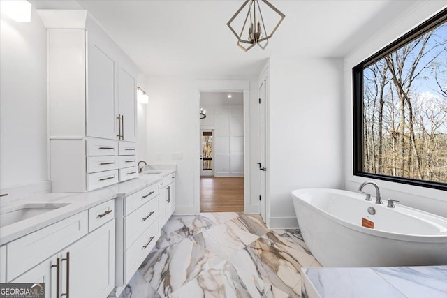 100 Forest Pl, Forsyth, GA 31029 - bathroom featuring marble look tiles, a soaking tub, vanity, and a chandelier