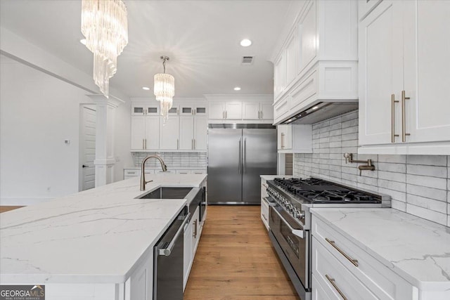 100 Forest Pl, Forsyth, GA 31029 - kitchen featuring high quality appliances, a chandelier, a sink, white cabinets, and backsplash