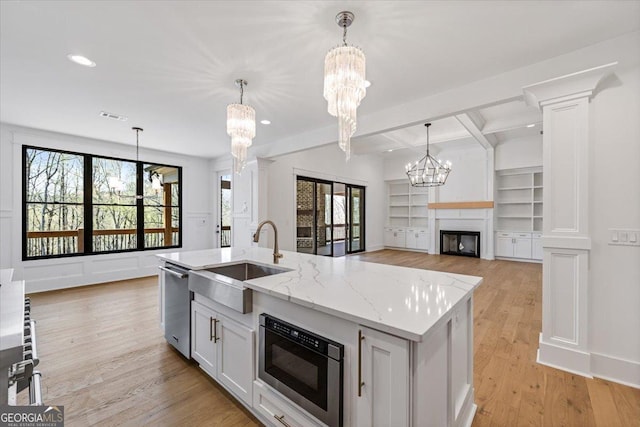 100 Forest Pl, Forsyth, GA 31029 - kitchen with a sink, a chandelier, stainless steel dishwasher, a fireplace, and light wood finished floors