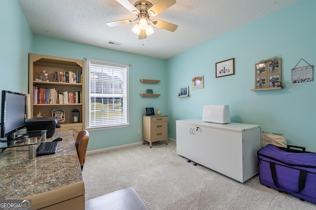 office area featuring a textured ceiling, visible vents, carpet, and a ceiling fan