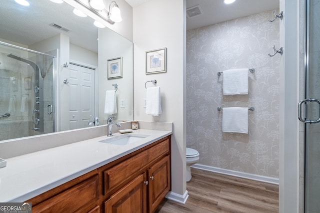 bathroom with vanity, visible vents, a shower stall, and wood finished floors