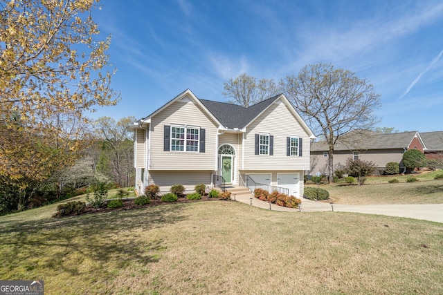 bi-level home with a front lawn, driveway, and an attached garage