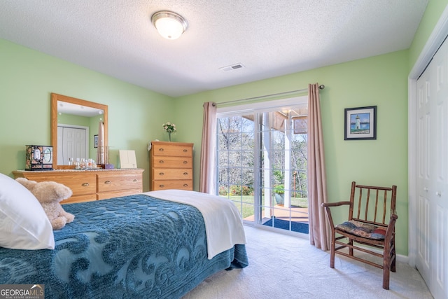 bedroom with a closet, a textured ceiling, visible vents, access to exterior, and carpet floors