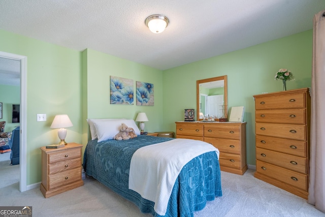 bedroom featuring baseboards, a textured ceiling, and light colored carpet
