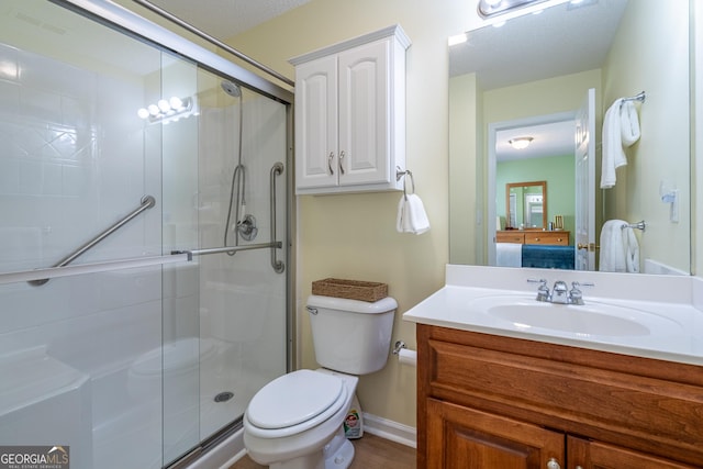 bathroom featuring toilet, vanity, and a stall shower