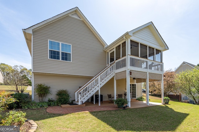 back of house with stairs, a sunroom, a patio area, and a lawn