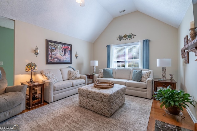 living area with visible vents, wood finished floors, and lofted ceiling