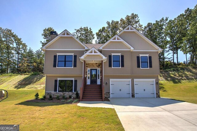 raised ranch with a front yard, stone siding, an attached garage, and a chimney