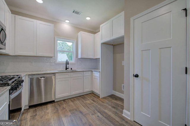 kitchen featuring white cabinets, a sink, visible vents, gas range oven, and dishwasher