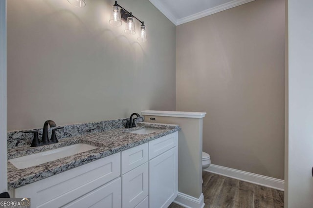 bathroom featuring wood finished floors, toilet, crown molding, and a sink