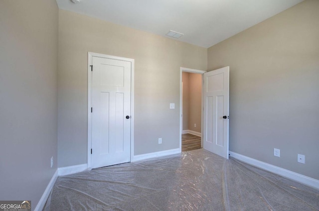 unfurnished bedroom with baseboards and carpet