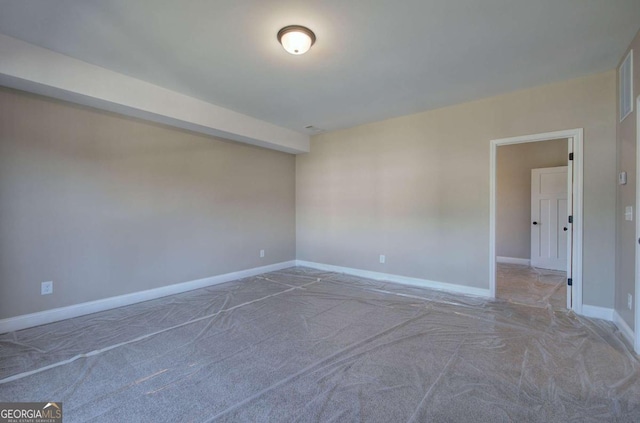 spare room with baseboards and carpet