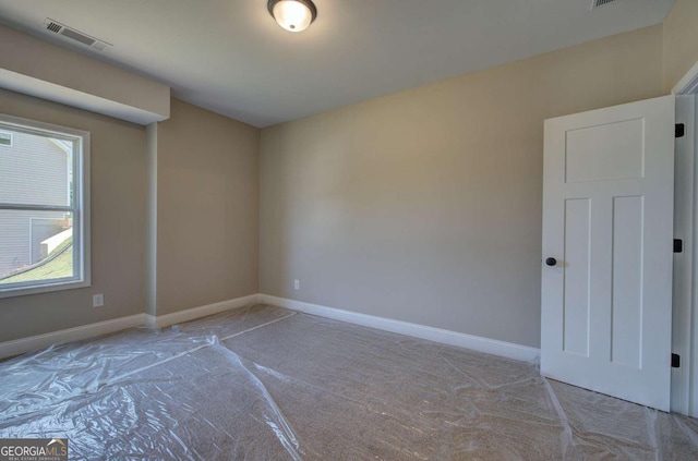 unfurnished room featuring visible vents, carpet floors, and baseboards