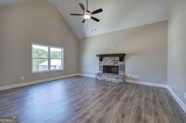 unfurnished living room featuring visible vents, wood finished floors, a ceiling fan, high vaulted ceiling, and a stone fireplace