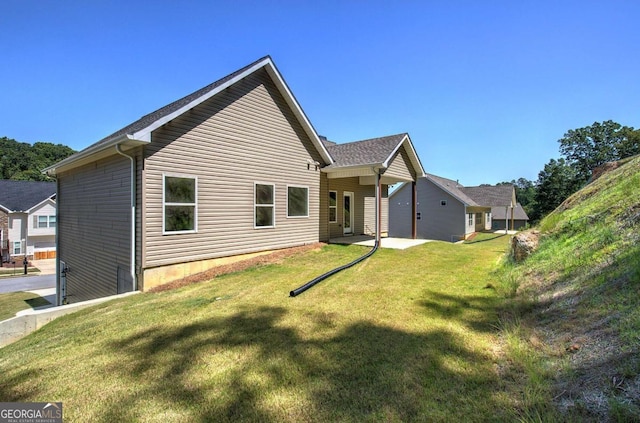back of property featuring a yard and a patio area