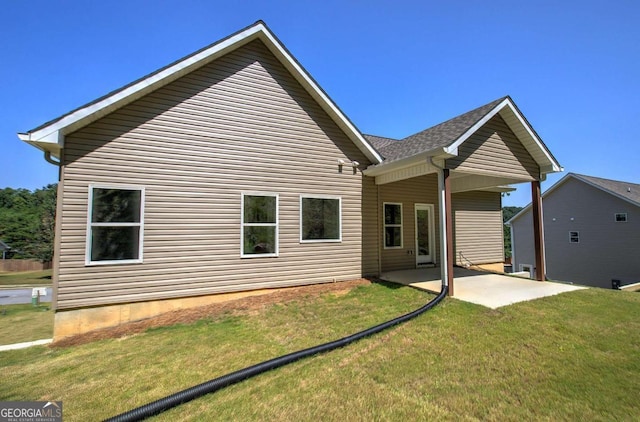 back of property featuring a patio and a yard