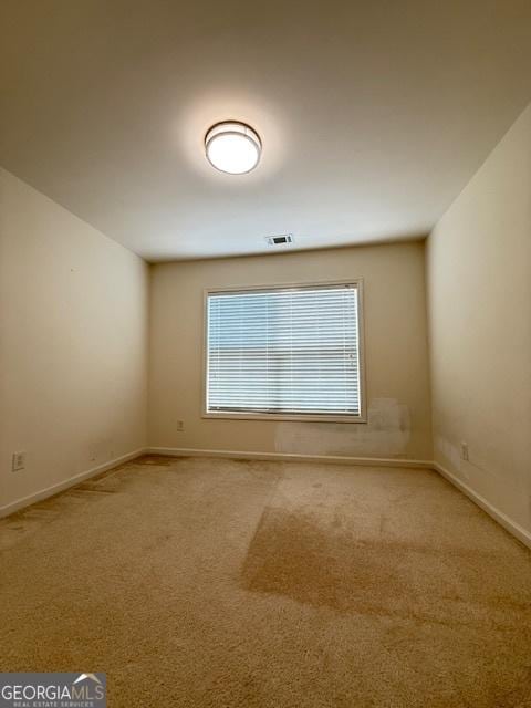 carpeted empty room with baseboards and visible vents