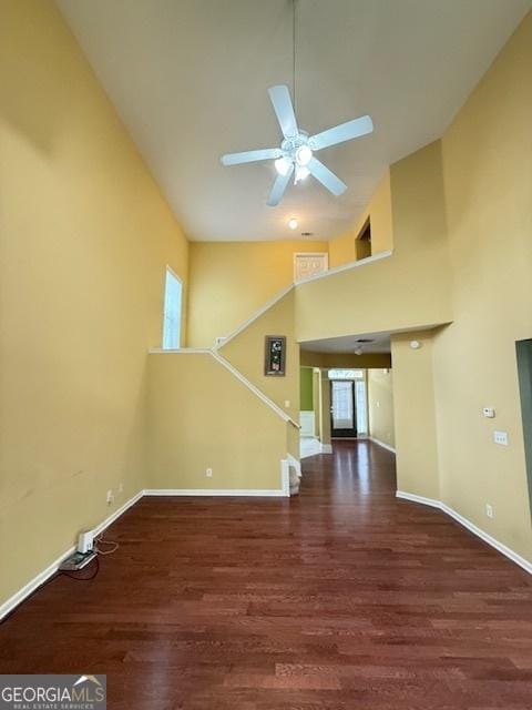 unfurnished living room featuring baseboards, high vaulted ceiling, ceiling fan, and wood finished floors