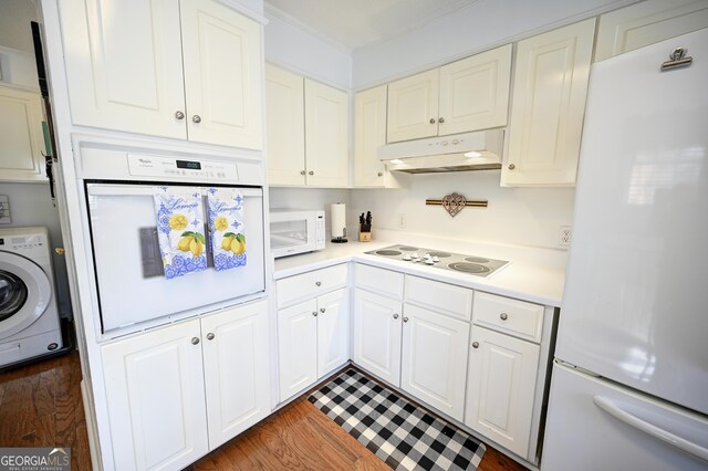 kitchen featuring light countertops, dark wood finished floors, washer / clothes dryer, under cabinet range hood, and white appliances