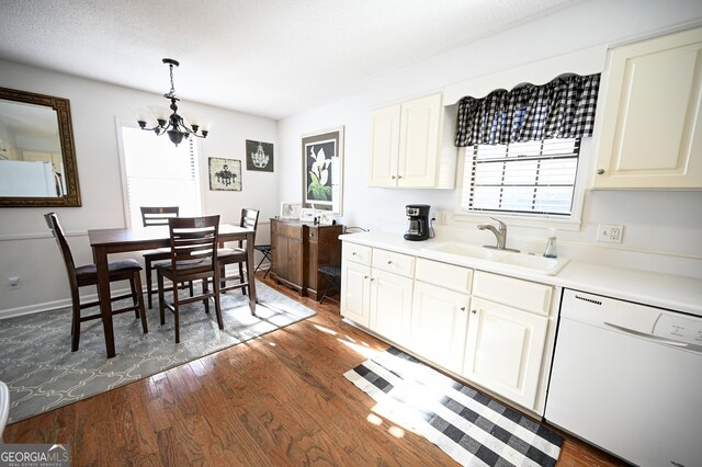 kitchen with an inviting chandelier, a sink, plenty of natural light, and white appliances