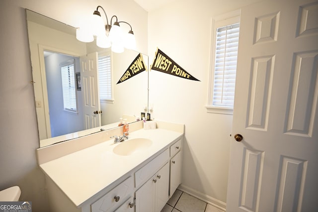 bathroom featuring baseboards, tile patterned flooring, vanity, and plenty of natural light