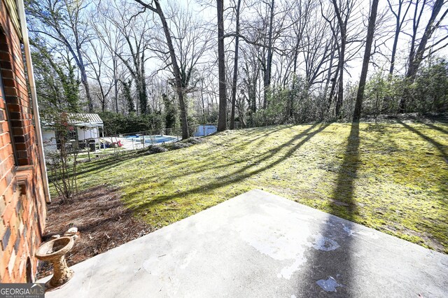 view of yard with an outbuilding, a patio area, and a fenced in pool