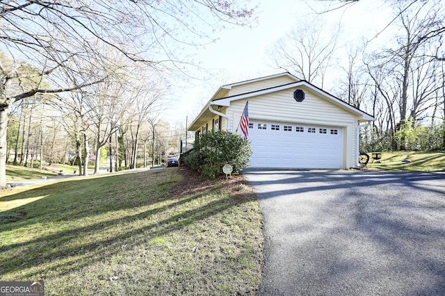 view of home's exterior featuring a lawn and aphalt driveway
