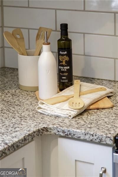room details with white cabinets and light stone counters