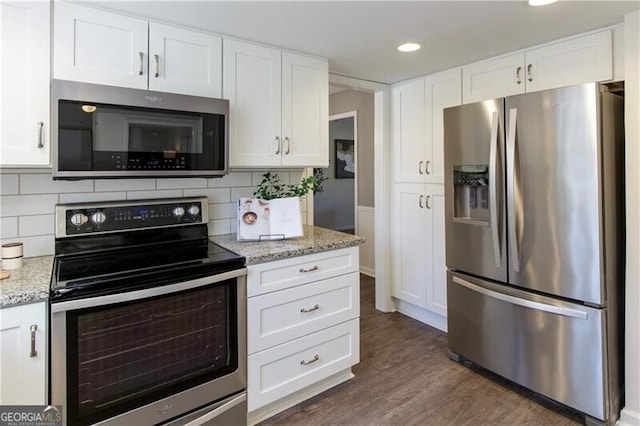 kitchen featuring white cabinetry, stainless steel appliances, and tasteful backsplash